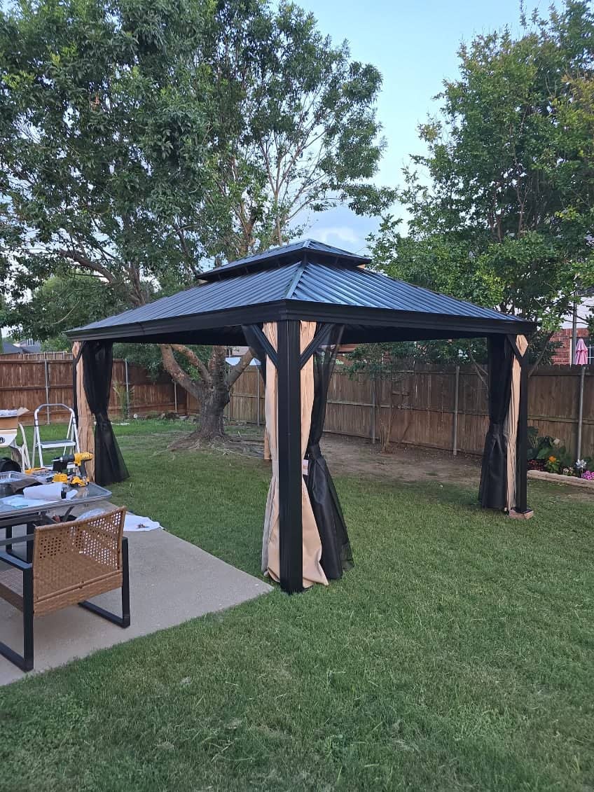 Hardtop metal gazebo with mosquito netting installed on a backyard deck