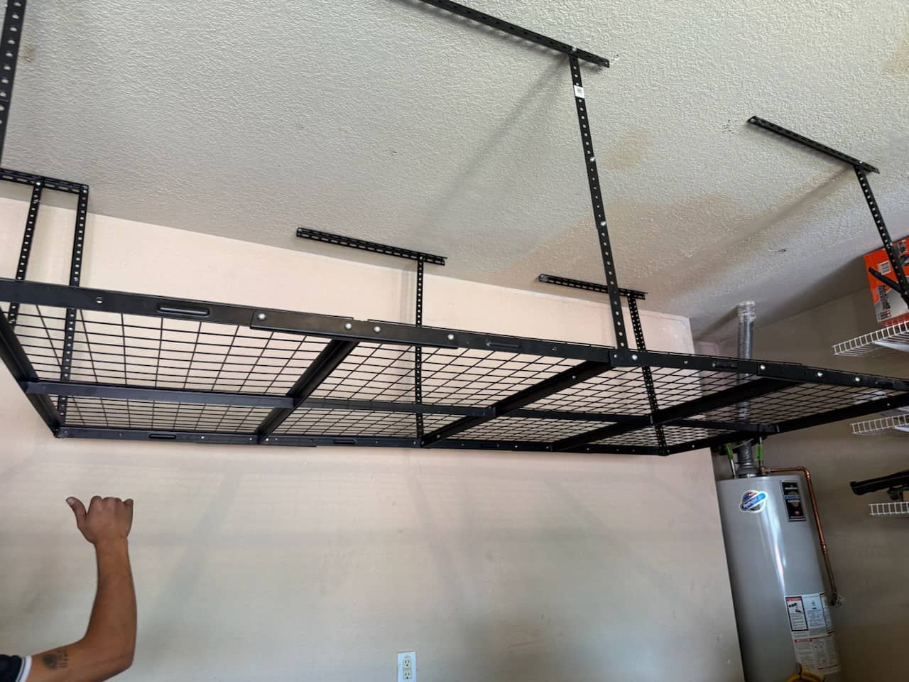 Ceiling-mounted overhead storage rack installed in a garage for seasonal storage