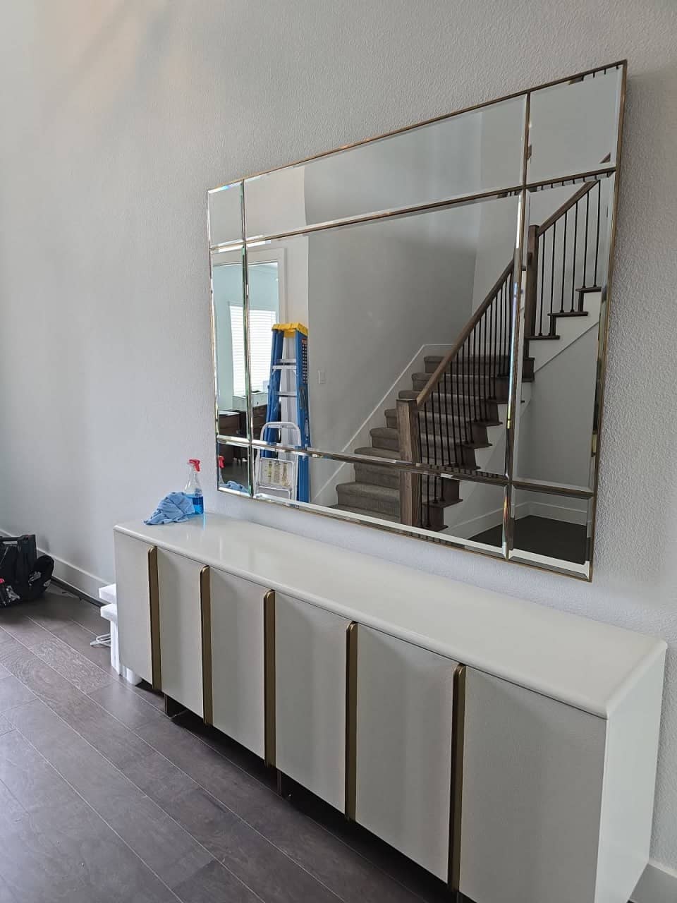 Large wall mirror professionally mounted and secured to a bedroom wall